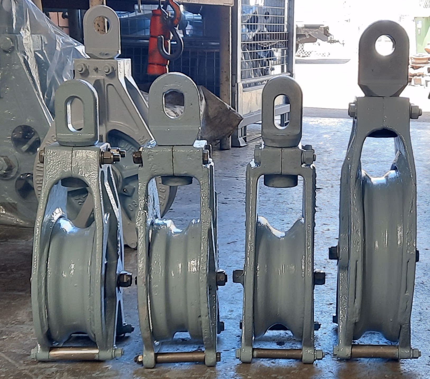 Four fully reconditioned trawl blocks freshly painted and lined up on the Seaworthy Engineering workshop floor
